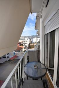 a table on a balcony with a view of a city at Eugenia's Luxury Apart in Volos