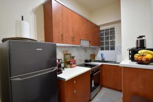 a kitchen with a black refrigerator and wooden cabinets at Eugenia's Luxury Apart in Volos