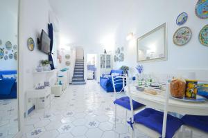 Habitación azul y blanca con mesa y sillas en Bellavista su Amalfi, en Amalfi