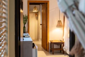 a hallway with a kitchen with a table and pendant lights at Pousada do Bosque in Trancoso