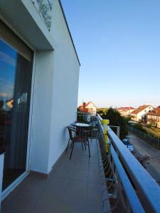 ein Balkon mit Tisch und Stühlen auf einem Gebäude in der Unterkunft Dom Gościnny Maja - Pokoje in Mrzeżyno