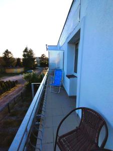 ein blauer Stuhl auf dem Balkon eines Gebäudes in der Unterkunft Dom Gościnny Maja - Pokoje in Mrzeżyno