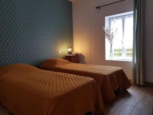 a hotel room with two beds and a window at Gîte à Saint André des Eaux in Saint-André-des-Eaux