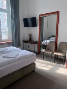 sypialnia z łóżkiem, lustrem, łóżkiem i krzesłem w obiekcie Zamek Nowęcin w Łebie