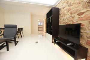 a living room with a television and a table and chairs at Elegant studio at the Acropolis hills in Athens