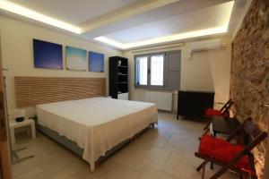 a bedroom with a bed and a chair in a room at Elegant studio at the Acropolis hills in Athens