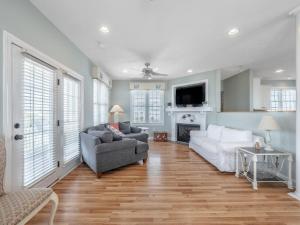 a living room with two couches and a fireplace at Skippers Hideout in North Topsail Beach