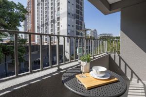 a table with a cup and aucer on a balcony at 360 My Moema in São Paulo