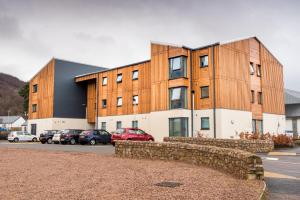 a building with cars parked in a parking lot at UHI Fort William - Campus Accommodation in Fort William