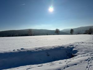 Un charco en un campo nevado con el sol en el cielo. en Etzauer Mühle im Taunus, en Weilrod 15 fotos más