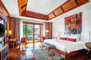 a bedroom with a large bed and a living room at RatiLanna Riverside Spa Resort in Chiang Mai
