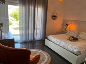 - une chambre avec un lit, une chaise et une fenêtre dans l'établissement Herdade dos Sepol, à Odivelas