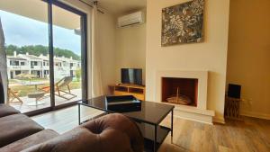 a living room with a couch and a fireplace at Apartamento com terraços privativos em resort de luxo, By QoZzy in Alvor