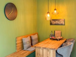 a dining room with a table and chairs and a clock at Moor Feeling Apartments Worpswede in Worpswede