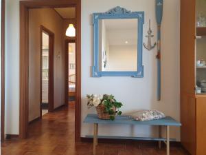 einen Flur mit einem blauen Spiegel und einem Tisch in der Unterkunft Temporary Home Silvi 3 in Silvi Marina
