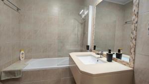 a bathroom with a sink and a bath tub at Apartamento com terraços privativos em resort de luxo, By QoZzy in Alvor +13 photos