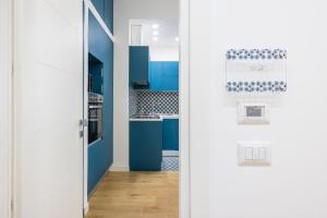 uma cozinha com armários azuis e uma porta branca em Residence Panoramic em Maiori