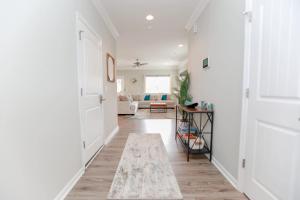 einen Flur mit einem Wohnzimmer mit weißen Wänden in der Unterkunft Sojourn Palm Tree Family Oasis 4 BR in North Camellia Acres