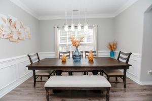 ein Esszimmer mit einem Holztisch und Stühlen in der Unterkunft Sojourn Palm Tree Family Oasis 4 BR in North Camellia Acres + 48 Fotos