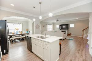 eine Küche und ein Wohnzimmer mit Spüle und Couch in der Unterkunft Sojourn Palm Tree Family Oasis 4 BR in North Camellia Acres