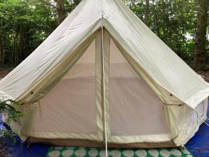 une tente installée dans les bois dans l'établissement WoodLands Basic Bell Tent 2, à Grantham