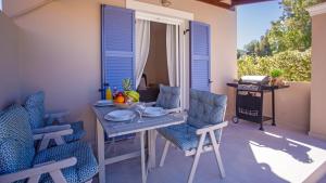 アギオス・ゲオルギオスにあるCosmos Villas Angelinaのテーブルと椅子が備わるパティオ(テーブルと椅子付)
