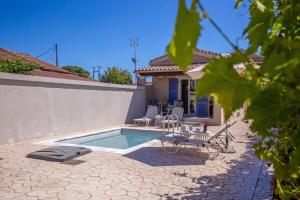 アギオス・ゲオルギオスにあるCosmos Villas Angelinaのスイミングプール(椅子、テーブル付)、