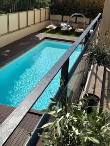 une piscine avec une terrasse en bois et une piscine dans l'établissement Hôtel Gallia Cannes, à Cannes