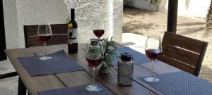 a table with wine glasses and a bottle of wine at Sylvia's house at Vagia in Vaia