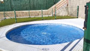 a circular pool of blue water with a fence at Apartment Aire del Mar in Liencres +15 photos