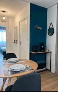 ein Esszimmer mit einem Tisch und einer blauen Wand in der Unterkunft T2 Neuf Lattes entre la VILLE, MER, NATURE 10 mn in Lattes