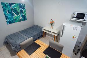 Una pequeña habitación con una cama y una nevera. en Departamentos Marilian, en Salta