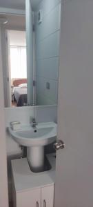 un baño con lavabo y espejo en Departamento Parque O'Higgins, en Santiago
