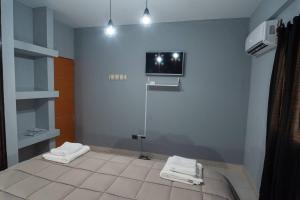 baño con 2 toallas y TV en la pared en Departamentos Marilian, en Salta
