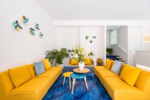 a living room with a yellow couch and a table at Residence Panoramic in Maiori