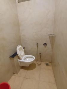 a bathroom with a white toilet in a stall at Hotel Lakshya Sheesh Mahal Indore in Indore