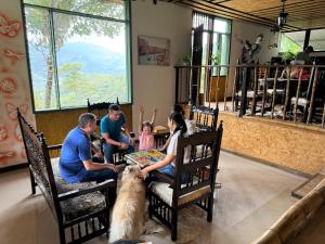 un gruppo di persone sedute a un tavolo con un cane di Eco hotel Birdland en Buga Valle a La Habana