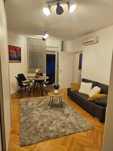 a living room with a couch and a table at Mali Raj - self check in in Osijek
