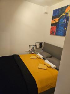 a bedroom with a bed with a yellow blanket at Mali Raj - self check in in Osijek