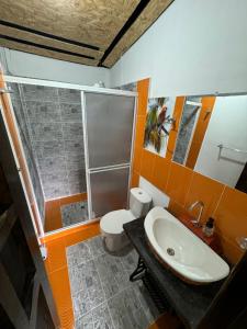 e bagno con servizi igienici, lavandino e doccia. di Eco hotel Birdland en Buga Valle a La Habana