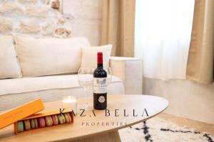 a bottle of wine sitting on a table with a glass at KAZA BELLA - Haut Marais Modern flat with small pool in Paris