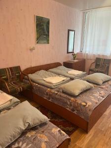 a room with three beds and two chairs at Apartmentai Baltoji Ramune in Palanga
