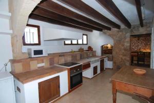 a large kitchen with wooden counters and white appliances at Bonita casa de campo típica Mallorquina in Sant Jordi