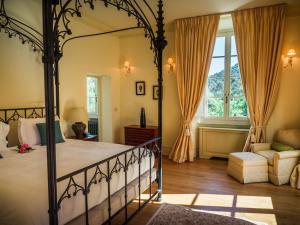 a bedroom with a canopy bed and a couch at Hotel Villa Casanova in Lucca