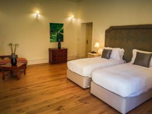 a hotel room with two beds and a table at Hotel Villa Casanova in Lucca