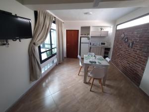 ein Esszimmer mit einem Tisch und einer Ziegelwand in der Unterkunft Jujuy Boutique in San Salvador de Jujuy