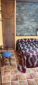 una camera con un letto, una sedia e una parete di CASA RURAL EL TEJAR a San Clemente