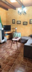 un soggiorno con un divano e un tavolo di CASA RURAL EL TEJAR a San Clemente