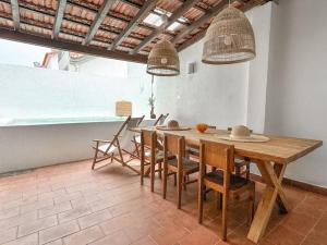 una sala da pranzo con tavolo e sedie in legno di Costa Inn Beach House with Pool by Homeful Homes a Costa da Caparica