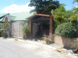 a brick house with a green roof and a driveway at Mactan Cebu House in Cebu City